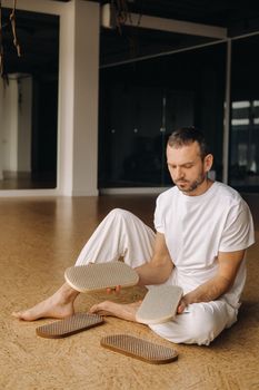 A man holds in his hands boards with nails for yoga classes.
