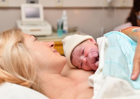 Mom and newborn baby skin to the skin after birth