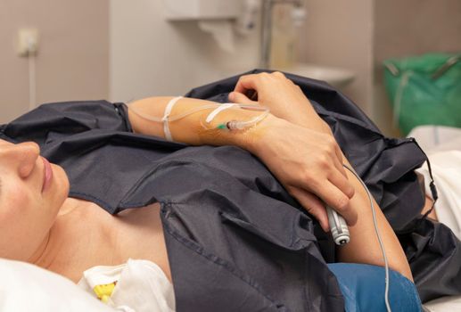 The woman in a delivery room with a dropper and push the remote button for a regular dose of epidural anesthesia