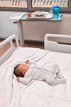 Newborn baby sleeping in a hospital bed