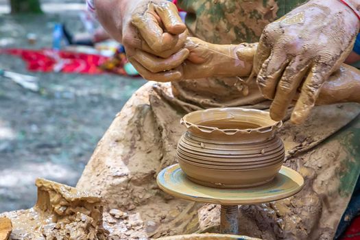 A master of pottery craftsmanship teaches a child who wants to learn how to sculpt a jug. Pottery master class.