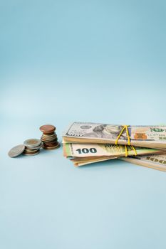 Multicurrency banknotes, euro coins, dollars on a blue background. The concept of the world economy in times of crisis, side view, space for an inscription