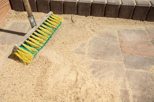 Brushing paving stones with sand, sunny day