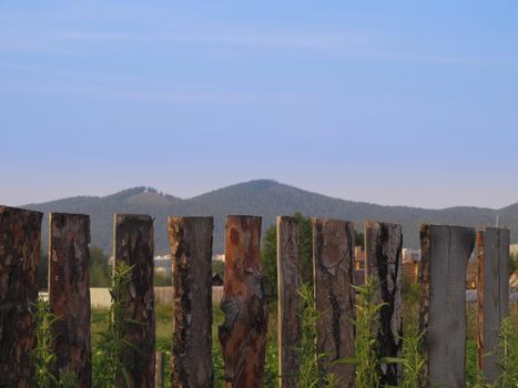 Old wooden fence against the backdrop of mountains