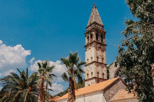 Historic city of Perast at Bay of Kotor in summer, Montenegro. Scenic panorama view of the historic town of Perast at famous Bay of Kotor with blooming flowers on a beautiful sunny day with blue sky and clouds in summer, Montenegro, southern Europe