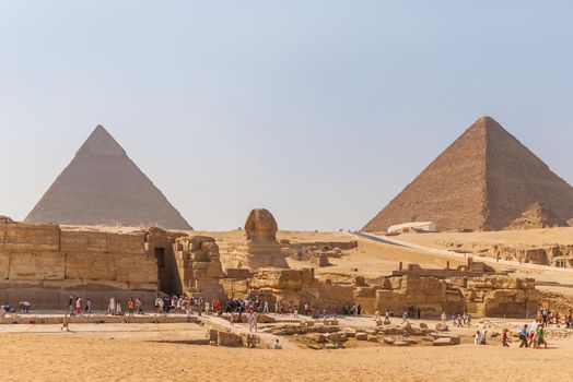 CAIRO, EGYPT - September 11, 2008. Groups of tourists on excursion near Statue of Sphinx and Great Pyramid of Giza.