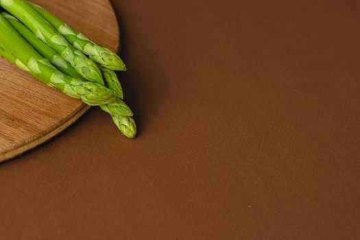 branches of fresh green asparagus on a wooden background, top view
