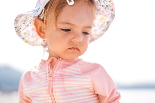 Little girl in a panama hat looks down. Portrait. High quality photo