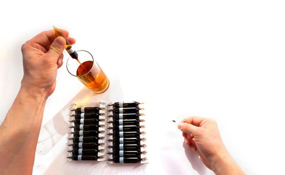 pour solution from an ampoule into a glass, dilute with water. horizontal perspective view of many brown ampoules set in pharmaceutical packaging white container