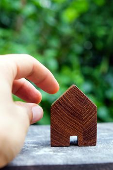 wood house model on wood table with green nature background , eco house icon concept.