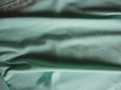 crumpled teal green fabric texture useful as a background