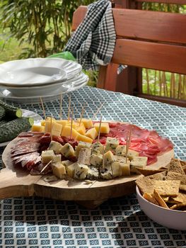 Meat and cheese slices on a wooden stand on the table. High quality photo