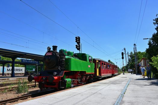 Brno - Czech Republic. June 18, 2022. Beautiful old Czech train with steam locomotive. Concept for retro, travel and train travel. Train tracks and a cruise train in the countryside.