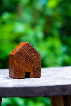wood house model on wood table with green nature background , eco house icon concept.