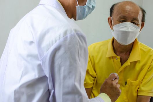 doctor checks the heartbeat of an elderly man