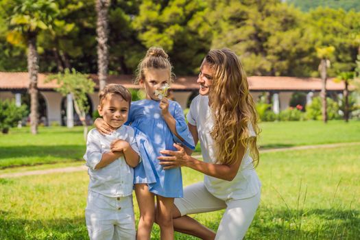 Happy family outdoors on the grass in a park, smiling faces, having fun.