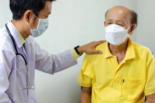 doctor held his shoulder and talked to an elderly man who was sick to give encouragement.