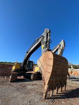 Caterpillar bulldozer with a huge bucket stands near a quarry. High quality photo