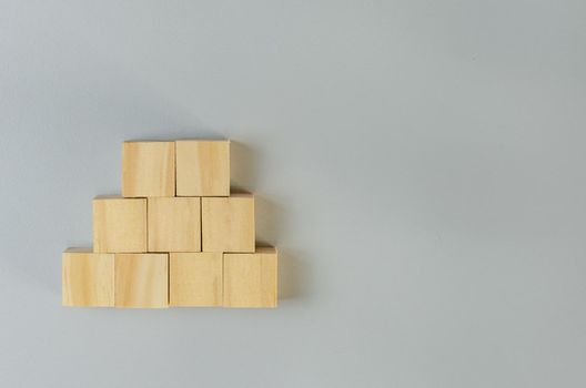 Blank wooden cubes for icons or symbols on gray background.