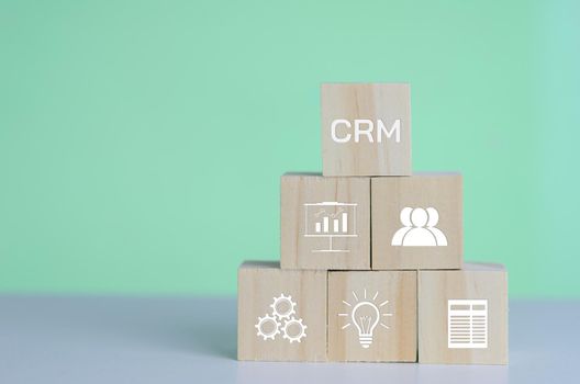 Wooden cubes with CRM  Customer relationship management automation system software symbol on background and copy space.Business concepts.