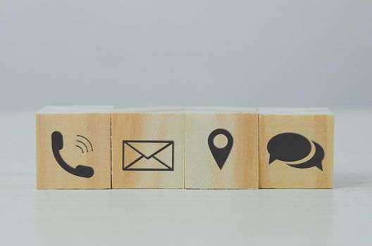 wooden cube block icon letter telephone location on table.Business communication and social network concept.