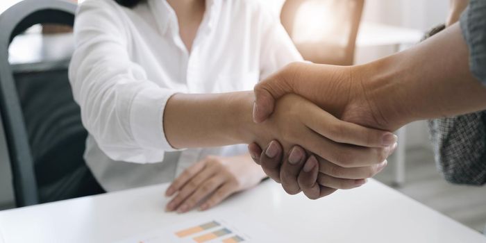 A close-up picture of a business shaking hands on a business cooperation agreement in office. Concept of Cooperation business and success.