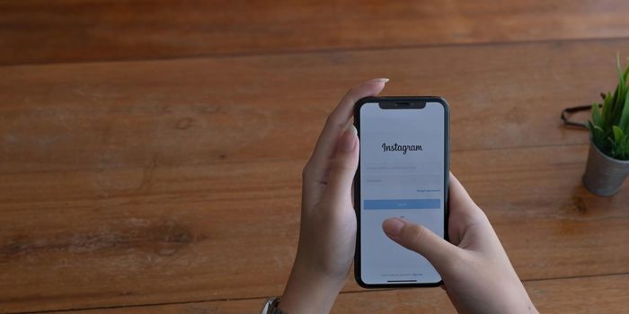 CHIANG MAI, THAILAND - JUL 10, 2022 A woman holds Apple iPhone X with Instagram application on the screen at cafe. Instagram is a photo-sharing app for smartphones..