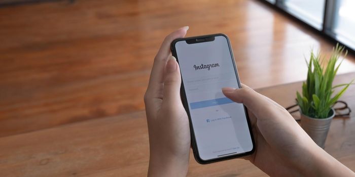 CHIANG MAI, THAILAND - JUL 10, 2022 A woman holds Apple iPhone X with Instagram application on the screen at cafe. Instagram is a photo-sharing app for smartphones..