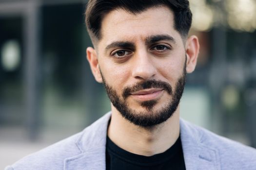 Caucasian bearded young man in formal outfit looking to camera outside on street. Feel happy businessman portrait business beautiful modern manager pretty