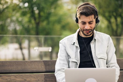 Caucasian business man wearing headphones communicating by video call. Ethnic businessman speaking looking at laptop computer, online conference distance office chat, virtual training concept.