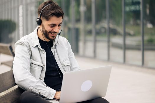 Ethnic businessman speaking looking at laptop computer, online conference distance office chat, virtual training concept. Caucasian business man wearing headphones communicating by video call.