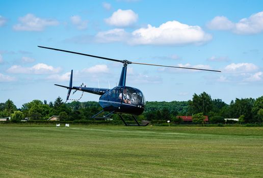 Breclav, Czech Republic - July 02, 2022 Aviation Day. Robinson R-44 helicoptership over the airport at low altitude