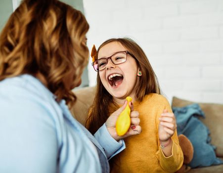 mother and daughter playing and having fun at home