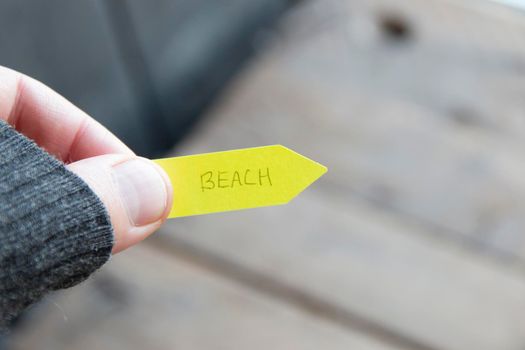 Beach. A man holds a pointer with an inscription. High quality photo