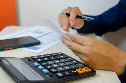 Business Man using calculator at a desk. Business finance, tax, economy
loan and investment concepts.