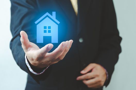 real estate ideas house trading Businessman holding house icon. House on hand. Insurance and safety concept. Symbol of house.