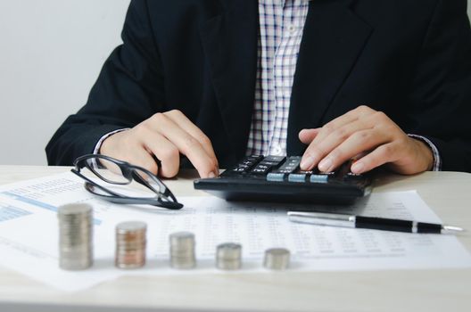 Male hands holding calculator and coins paper documents .Business economic finance tax and investment concepts.