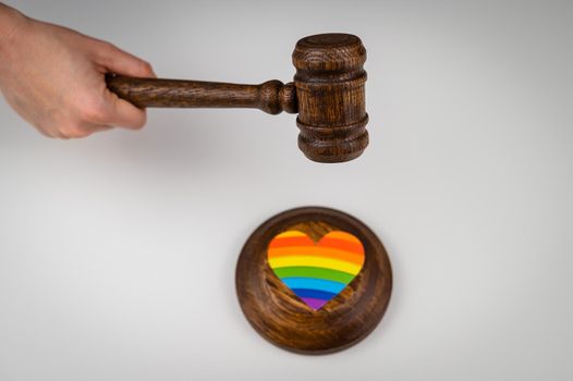 The judge hits a heart with a rainbow flag with a gavel