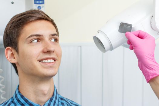 Female dentist and patient in the dental office are looking at a dental x-ray. Dentistry