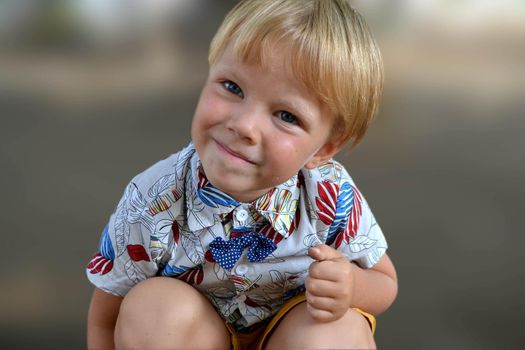 Blond boy 4 years old playing on a children playground and has fun. High quality photo