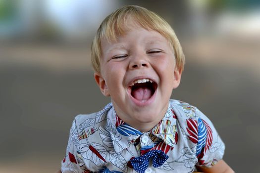 Blond boy 4 years old playing on a children playground and has fun. High quality photo