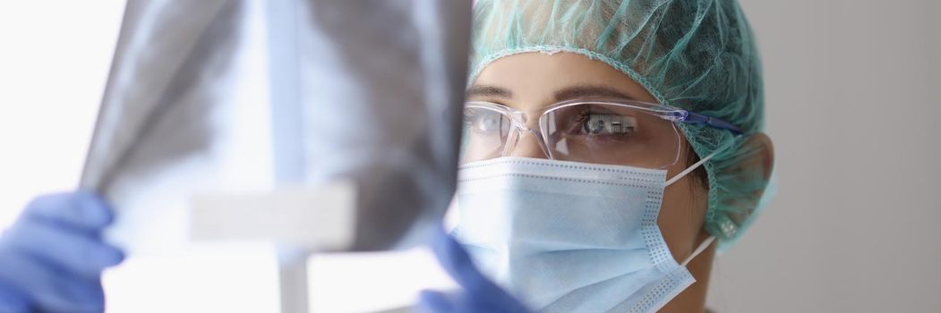 Portrait of female doctor examine x ray scan on light, patients lungs diagnostic. Medical worker get clear about diagnose. Covid, disease, medicine concept