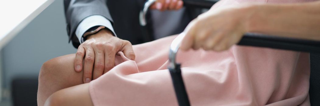 Close-up of woman office worker feeling ashamed because of her boss harassment. Man touch secretary knee on working place. Harassment at workplace concept