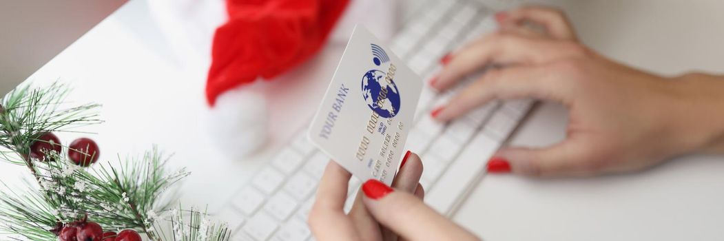 Close-up of woman typing credit card number on keyboard, want to pay online in cashless way. Order presents for new year. Holiday, gift, shopping concept