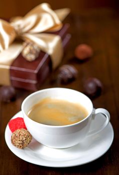 a cup of coffee and candy on vintage wooden background