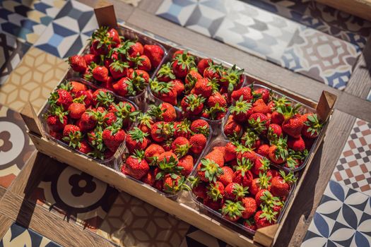 wooden box full of fresh organic strawberries on white background. top view.