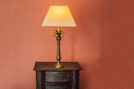 Bright eco light in the corner of a modern bedroom. New led technology meets traditional interior design. Lamp is creating cozy atmosphere in room. Wooden, glass table, blue curtains.