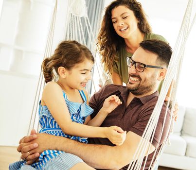 Family having fun playing on a swing at home