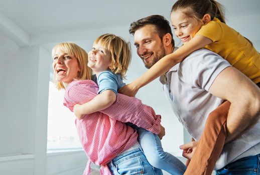 Familyof four father, mather, daughter and son having fun playing at home