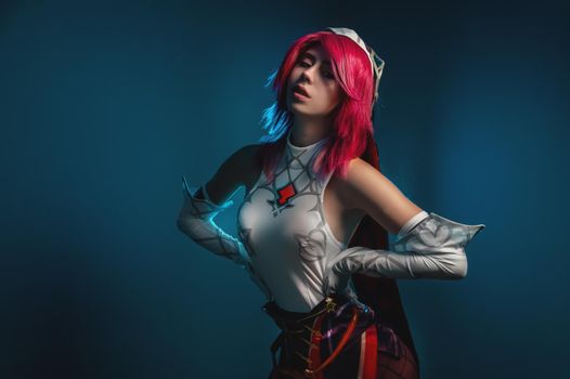 Young beautiful caucasian girl in sexy cosplay with pink hair and voluminous breasts.